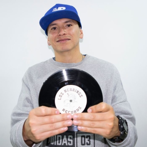 Fotografía de DJ Boka con un disco de acetato en sus manos