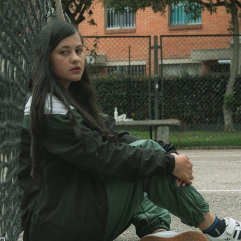 Fotografía de Selene recostada sobre la malla de un parque
